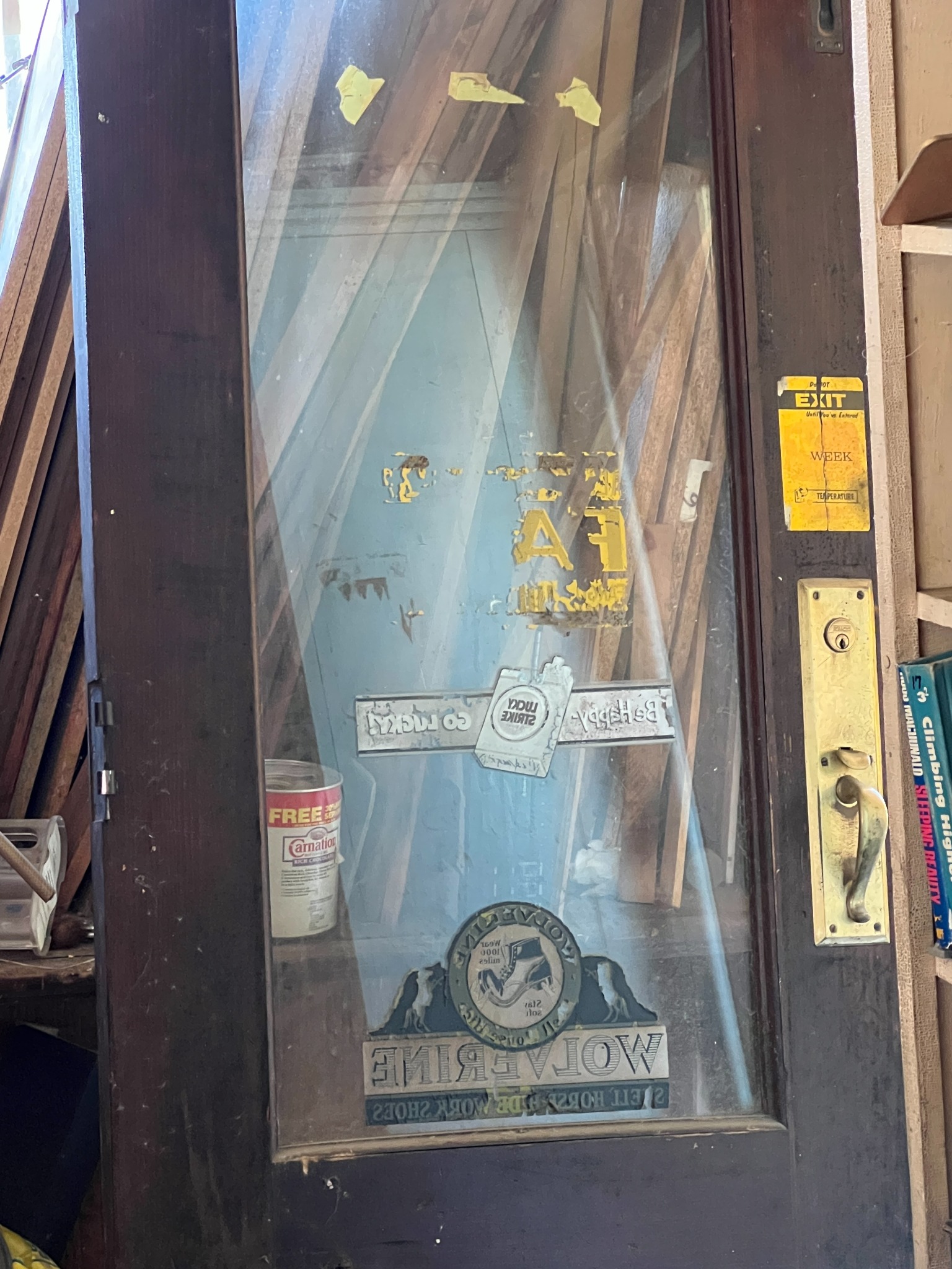 The glass door, with surviving advertisements and its brass handle.